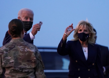 U.S. President Joe Biden and first lady Jill Biden hold up challenge coins, as they depart RAF Mildenhall, ahead of the G7 Summit, near Mildenhall, Britain June 9, 2021. REUTERS/Kevin Lamarque