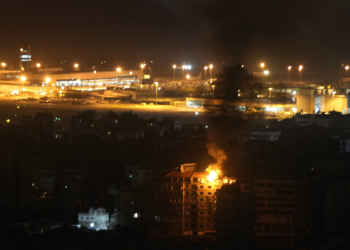 Flames and smoke rise from a building that was hit by an Israeli airstrike in Dahiyeh, as Rafik Hariri International airport is seen in the background, in Beirut, Lebanon, Friday, Oct. 4, 2024. (AP Photo/Hussein Malla)